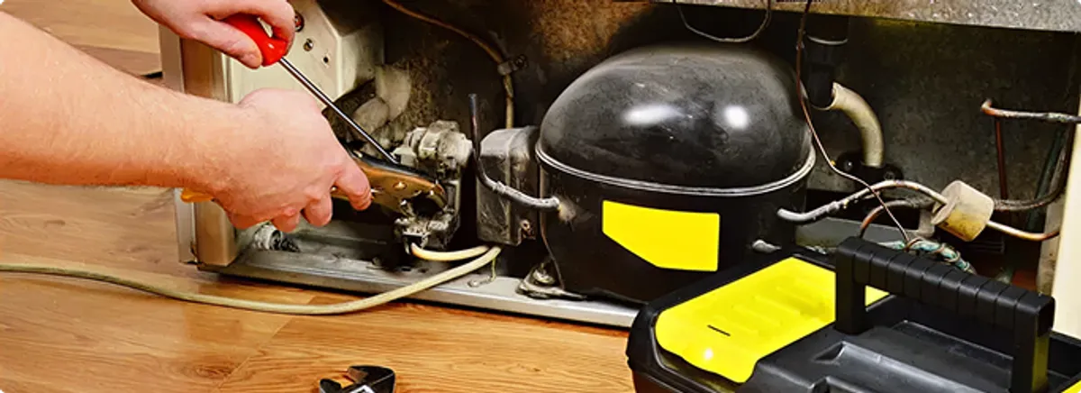 Refrigerator repair technician fixing the compressor and wiring in Ft Mitchell, KY