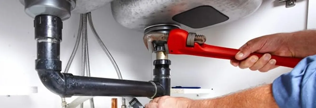 Garbage disposal repair technician tightening the sink drain and disposal connection in Cincinnati, OH